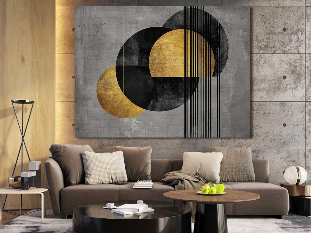 Gold and black wall art on gray concrete wall in living space