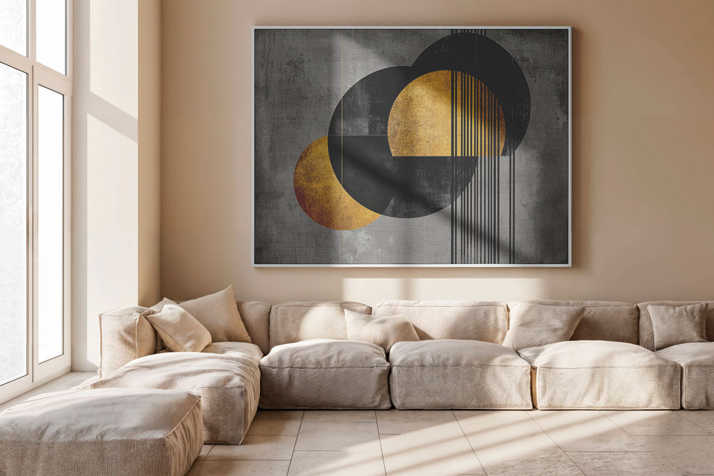 Gold and black art hanging above a light sofa in modern living room
