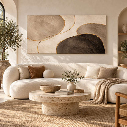 Canvas print of abstract pebble-shaped forms displayed above a sofa in a bright modern living room