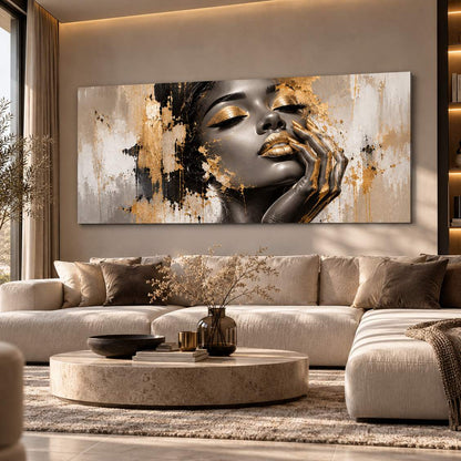 Monochrome gold-accent portrait canvas print displayed above a beige sectional sofa in a living room
