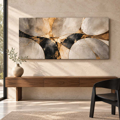 Abstract stone and gold canvas print displayed above a wooden console table with a black accent chair